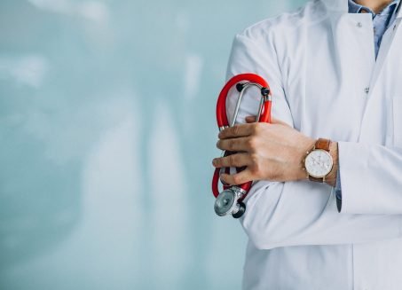Young handsome physician in a medical robe with stethoscope